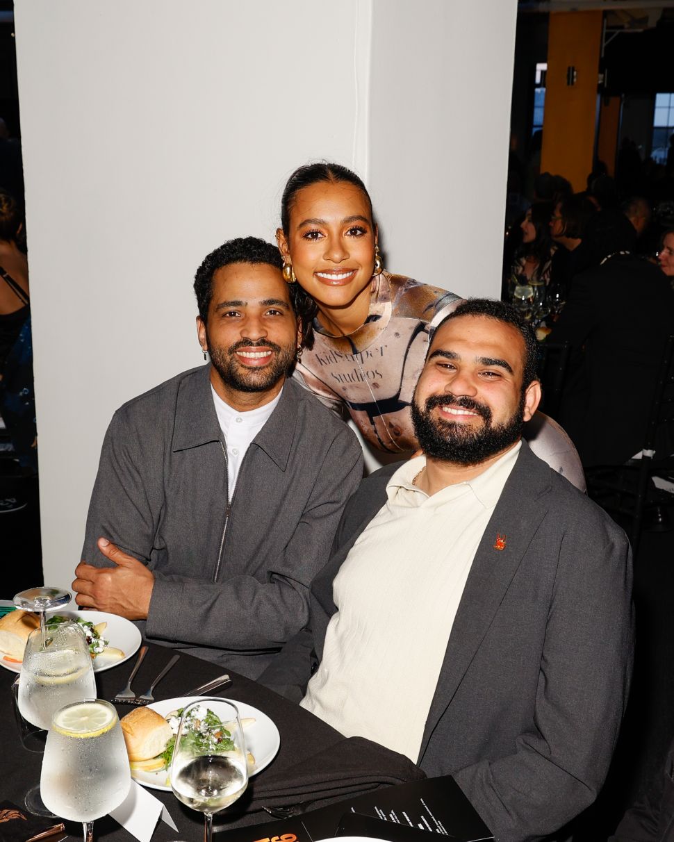 Two guests smiling and posing together in front of The Bronx Museum gala backdrop.