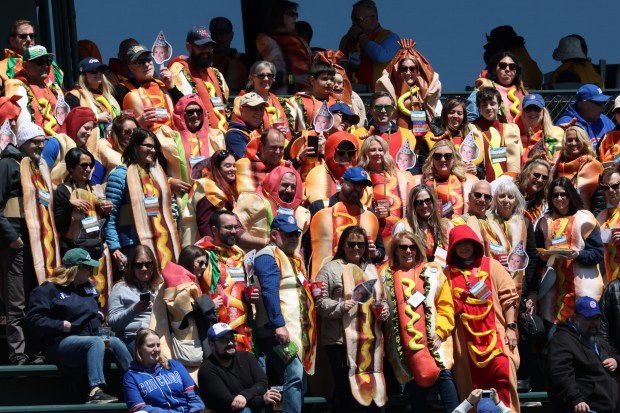 Fans wearing hot dog costumes in the left-field bleachers stand for pictures before a Cubs-Mets game Saturday, April 18, 2026, at Wrigley Field. (John J. Kim/Chicago Tribune)