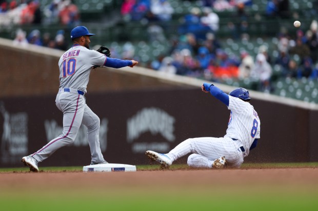 Mets second baseman Marcus Semien (10) throws to first after tagging out Cubs left fielder Ian Happ (8) during the second inning at Wrigley Field April 19, 2026, in Chicago. (Armando L. Sanchez/Chicago Tribune)