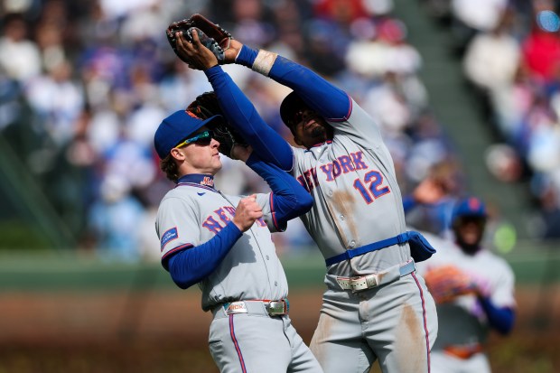 Mets shortstop Francisco Lindor (12) runs into Mets outfielder Carson Benge (3) while catching a ball from Cubs catcher Carson Kelly (15) during the seventh inning at Wrigley Field April 19, 2026, in Chicago. (Armando L. Sanchez/Chicago Tribune)
