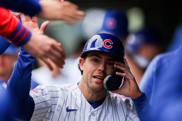 Cubs second baseman Scott Kingery (12) celebrates in the dugout after scoring off a RBI double from Cubs left fielder Michael Conforto (20) during the ninth inning against the Mets at Wrigley Field April 19, 2026, in Chicago. (Armando L. Sanchez/Chicago Tribune)