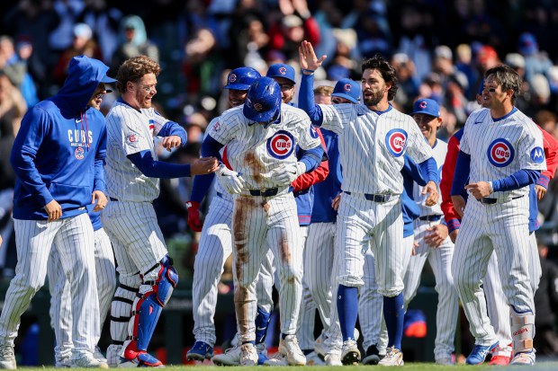 Cubs second baseman Nico Hoerner (2) celebrates with his team after hitting a walk-off sacrifice fly bringing in Cubs center fielder Pete Crow-Armstrong (4) to give the Cubs a, 2-1, win over the Mets at Wrigley Field April 19, 2026, in Chicago. (Armando L. Sanchez/Chicago Tribune)