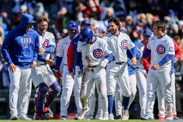 Cubs second baseman Nico Hoerner (2) celebrates with his team after hitting a walk-off sacrifice fly bringing in Cubs center fielder Pete Crow-Armstrong (4) to give the Cubs a, 2-1, win over the Mets at Wrigley Field April 19, 2026, in Chicago. (Armando L. Sanchez/Chicago Tribune)