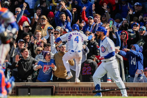 Cubs center fielder Pete Crow-Armstrong (4) celebrates with fans after scoring off Cubs second baseman Nico Hoerner's (2) walk-off sacrifice fly to give the Cubs a, 2-1, win over the Mets at Wrigley Field April 19, 2026, in Chicago. (Armando L. Sanchez/Chicago Tribune)