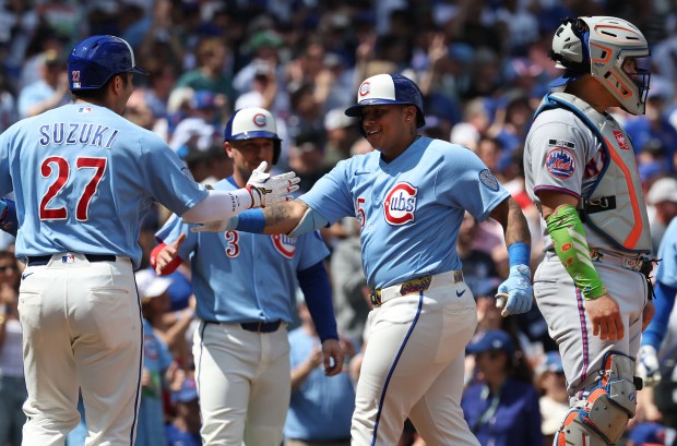 Chicago Cubs designated hitter Moisés Ballesteros (25) is congratulated by teammate Seiya Suzuki (27) after Ballesteros hit a three-run homer in the first inning of a game against the New York Mets at Wrigley Field in Chicago on April 17, 2026. (Chris Sweda/Chicago Tribune)