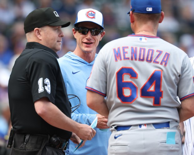 Chicago Cubs manager Craig Counsell (11) chats with home plate umpire Todd Tichenor (13) and New York Mets manager Carlos Mendoza (64) before the start of a game at Wrigley Field in Chicago on April 17, 2026. (Chris Sweda/Chicago Tribune)