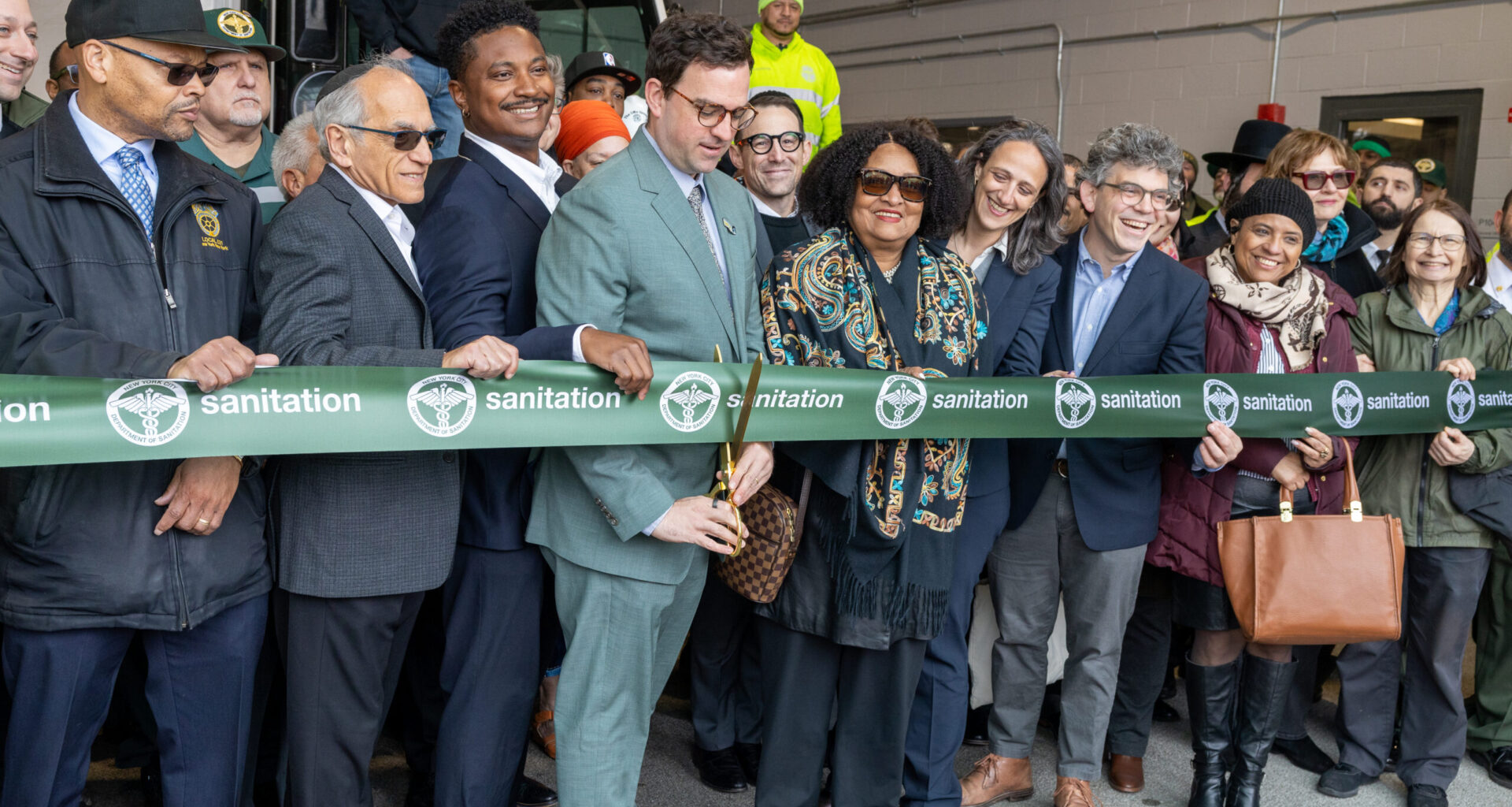 Participants in the ribbon-cutting, left to right: Ronald Prattis, vice president of Local 831; former DSNY Director of Real Estate Daniel Kline; Councilmember Chi Ossé; Sanitation Commissioner Gregory Anderson; former DSNY Assistant Commissioner Arlana Davis; Deputy Mayor for Operations Julia Kerson; Councilmember Lincoln Restler; and community advocates. Photo: DSNY