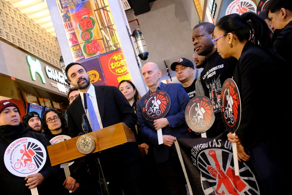 Zohran Mamdani speaks at a lectern during a press conference.