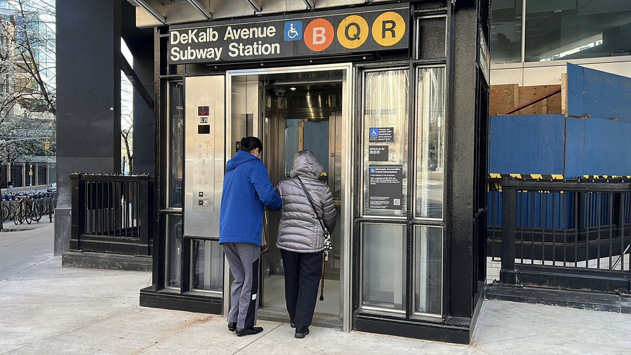 Riders at the DeKalb station elevator