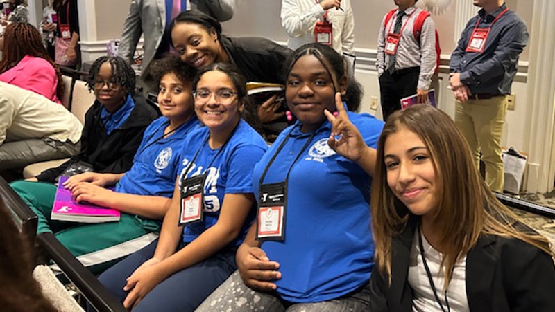 A photograph of a group of middle school students posing for a portrait inside the New York capitol building,