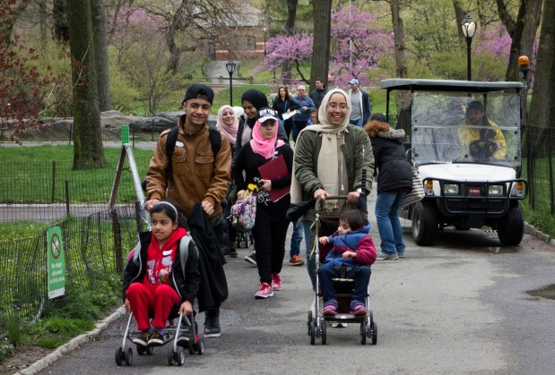 A group of Syrian refugee families walk through Central Park in 2017.
