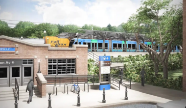 rendering showing a brick station building with a train in the background