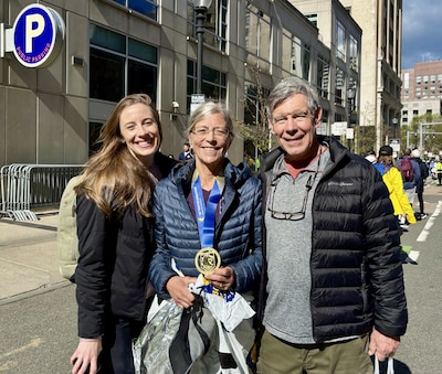 Marisa stands with her mom and another man outdoors.