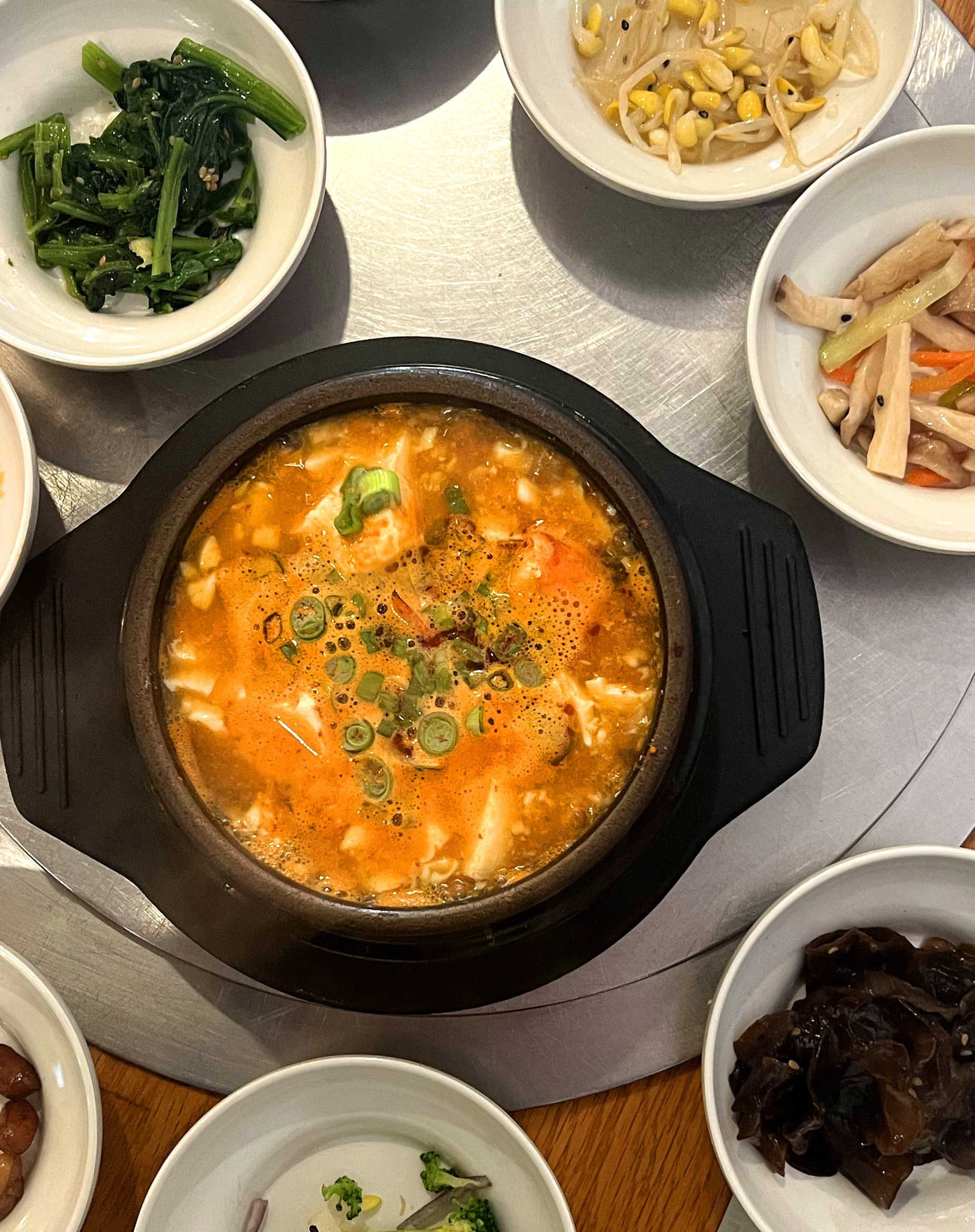 A bright orange stew alongside banchan.
