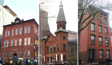 Color photo of three historic buildings: from left to right, a three story brick building, a church, and a four story brick building