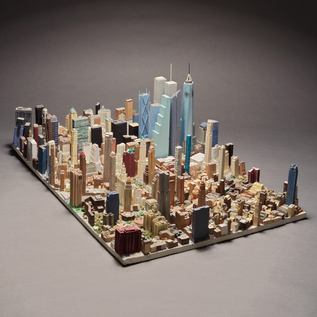 Isolated miniature model of Lower Manhattan with clustered skyscrapers displayed against a plain background.