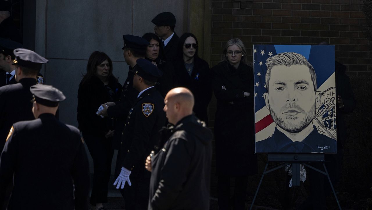 NYPD Officer Jonathan Diller's painting is seen during his funeral service in Massapequa Park on Saturday, March 30, 2024. (AP Photo/Jeenah Moon)