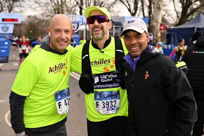two men wearing yellow and one man wearing black at a marathon