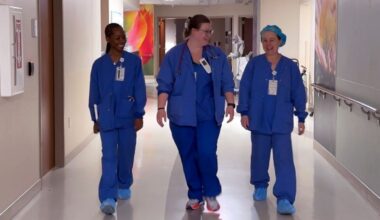 three nurses walk down a hallway