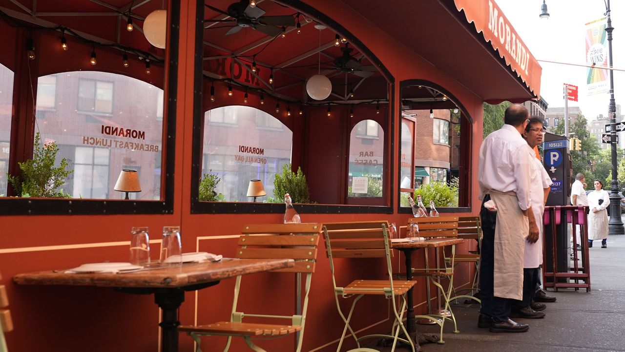 People talk outside an outdoor dining space in New York, Wednesday, July 31, 2024. (AP Photo/Pamela Smith)