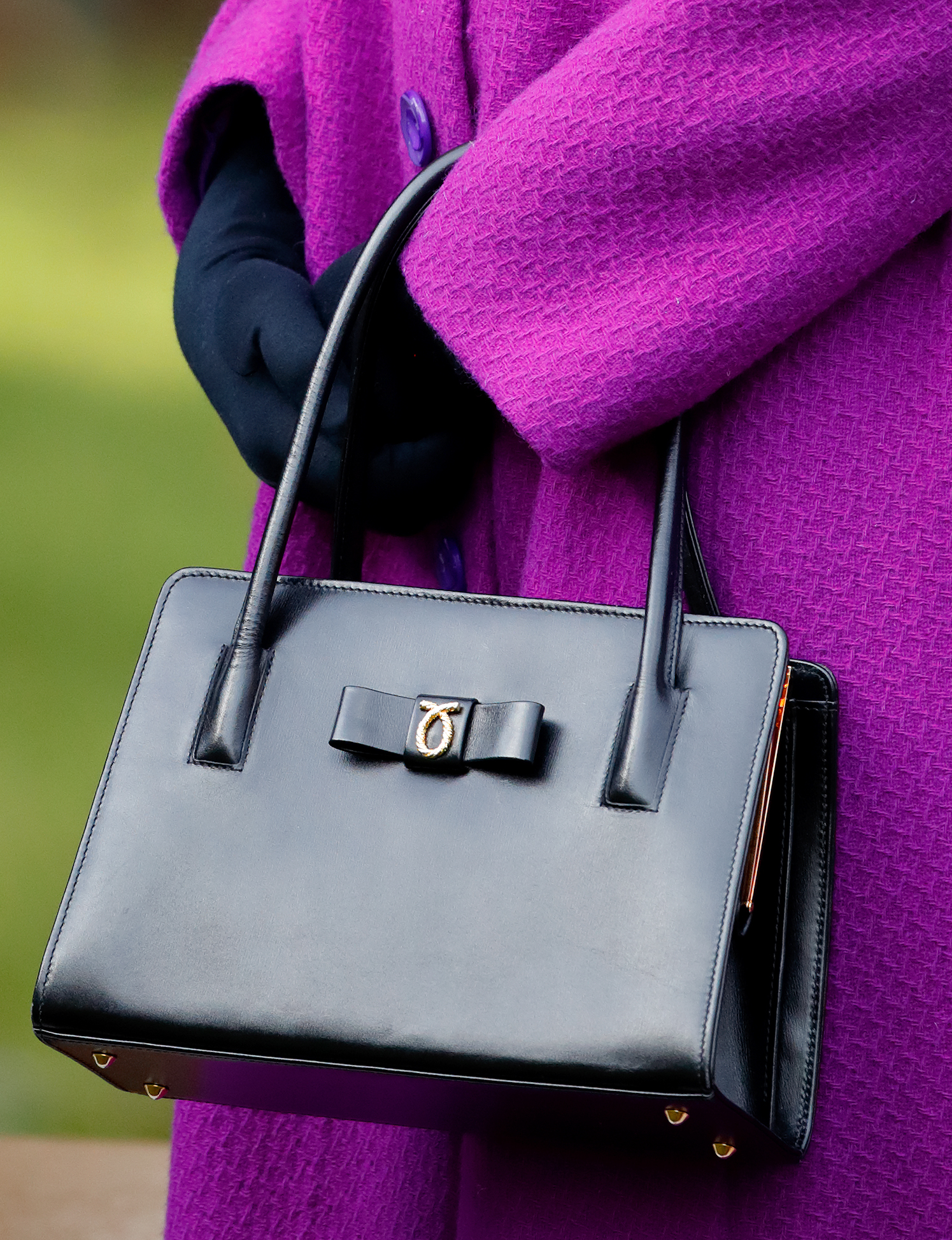Queen Elizabeth holding a black Launer handbag