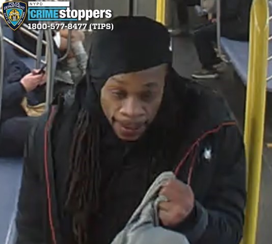 Man with dreadlocks wearing a black durag and black jacket.