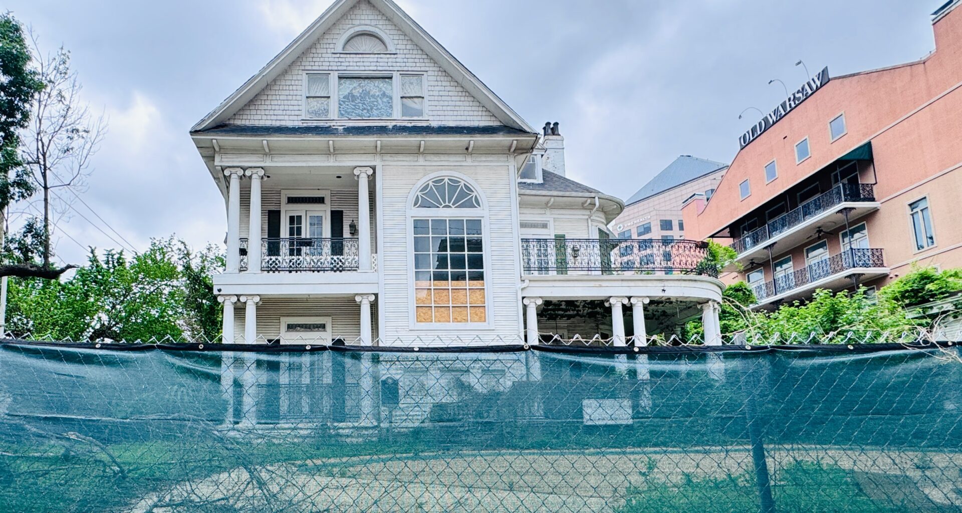 The hotel St. Germain in disrepair with a green construction fense around it.
