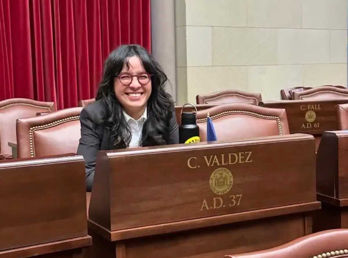 Claire Valdez, candidate for congress endorsed by Bernie Sanders, smiling while seated at desk.