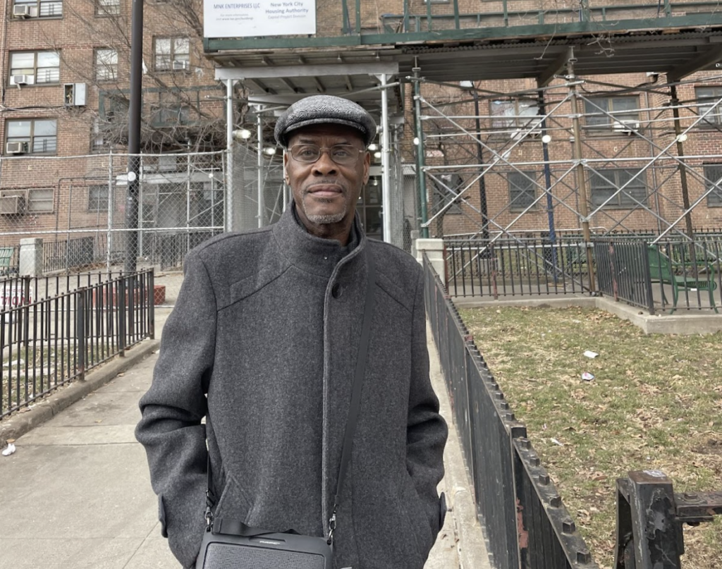 Wendell Harrison stands in front of the Mitchel Houses. (Credit: Carol Chen)