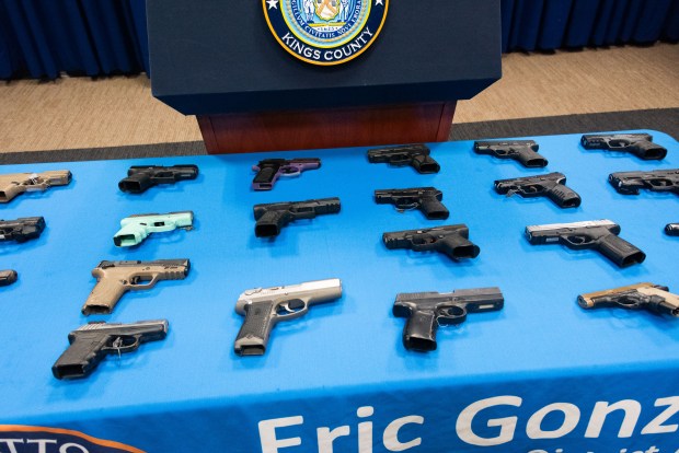 Seized guns are displayed as Brooklyn District Attorney Eric Gonzalez and NYPD Commissioner Jessica Tisch announce a gang takedown at the Kings County DA's Office in Brooklyn, New York on April 15, 2026. (Gardiner Anderson / New York Daily News)