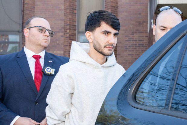 Tehron Sheraliev, suspect in the hit-and-run of 11-year-old Egot Mudaev, is pictured in police custody leaving the NYPD's 61st Precinct stationhouse in Brooklyn on Thursday, April 23, 2026. (Theodore Parisienne / New York Daily News)