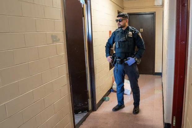 Police are pictured at the scene where a 43-year-old man was allegedly shot and killed by his 16-year-old stepson in an apartment building on Cumberland Walk in Brooklyn on Sunday April 12, 2026. (Theodore Parisienne / New York Daily News)
