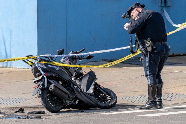 The NYPD Highway Patrol investigates a moped crash on Hinsdale St. and Pitkin Ave. in Brownsville, Brooklyn on Saturday. 