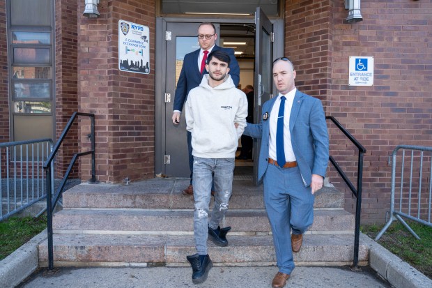 Tehron Sheraliev, suspect in the hit-and-run of 11-year-old Egot Mudaev, is pictured in police custody leaving the NYPD's 61st Precinct stationhouse in Brooklyn on Thursday, April 23, 2026. (Theodore Parisienne / New York Daily News)