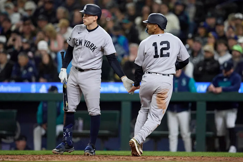 New York Yankees center fielder Trent Grisham (12) is greeted by first baseman Ben Rice after scoring on a throwing error during a game against the Seattle Mariners on Tuesday at T-Mobile Park in Seattle.