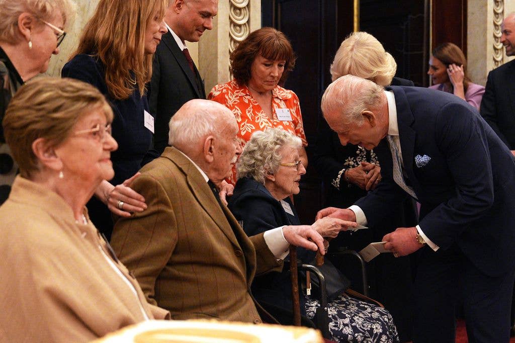 King Charles hands birthday cards to people turning 100 today at a reception in Buckingham Palace