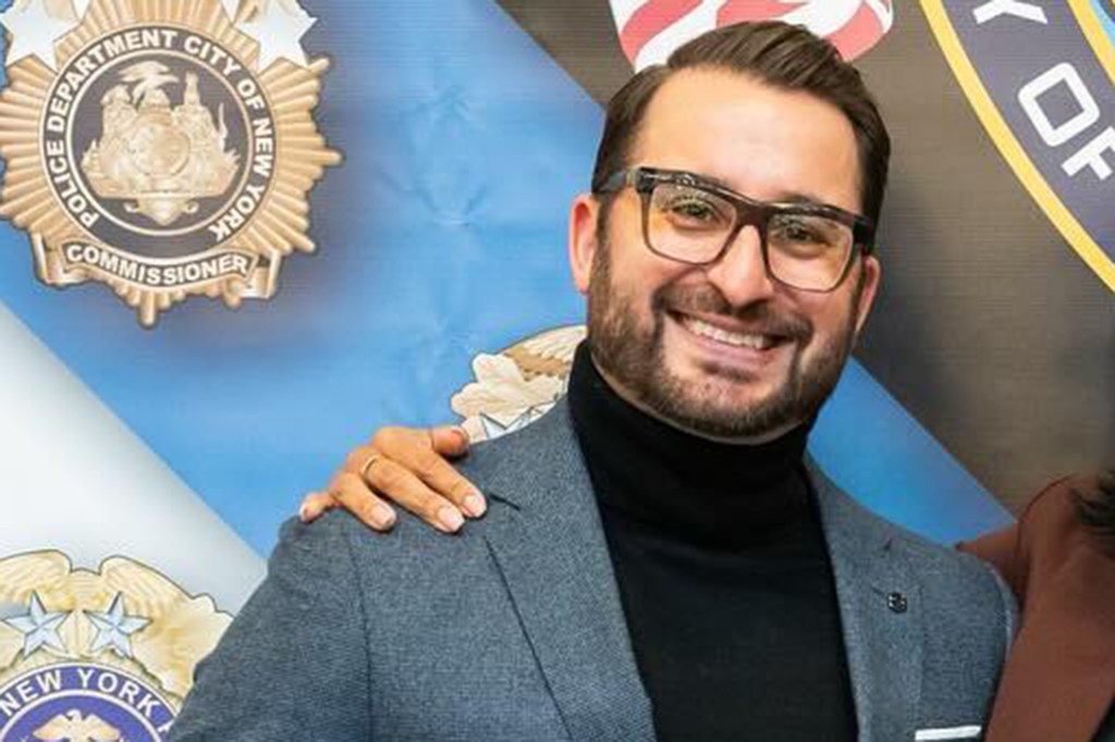 Psychologist Matthew Graziano smiling, with a hand on his shoulder, in front of a New York City Police Department emblem.