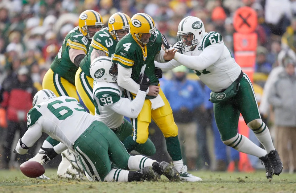 New York Jets defensive tackle Dewayne Robertson falls on a fumble as defensive end (99) Bryan Thomas and defensive end (67) Kimo Von Oelhoffen tackle Green Bay Packers quarterback (4) Brett Favre.