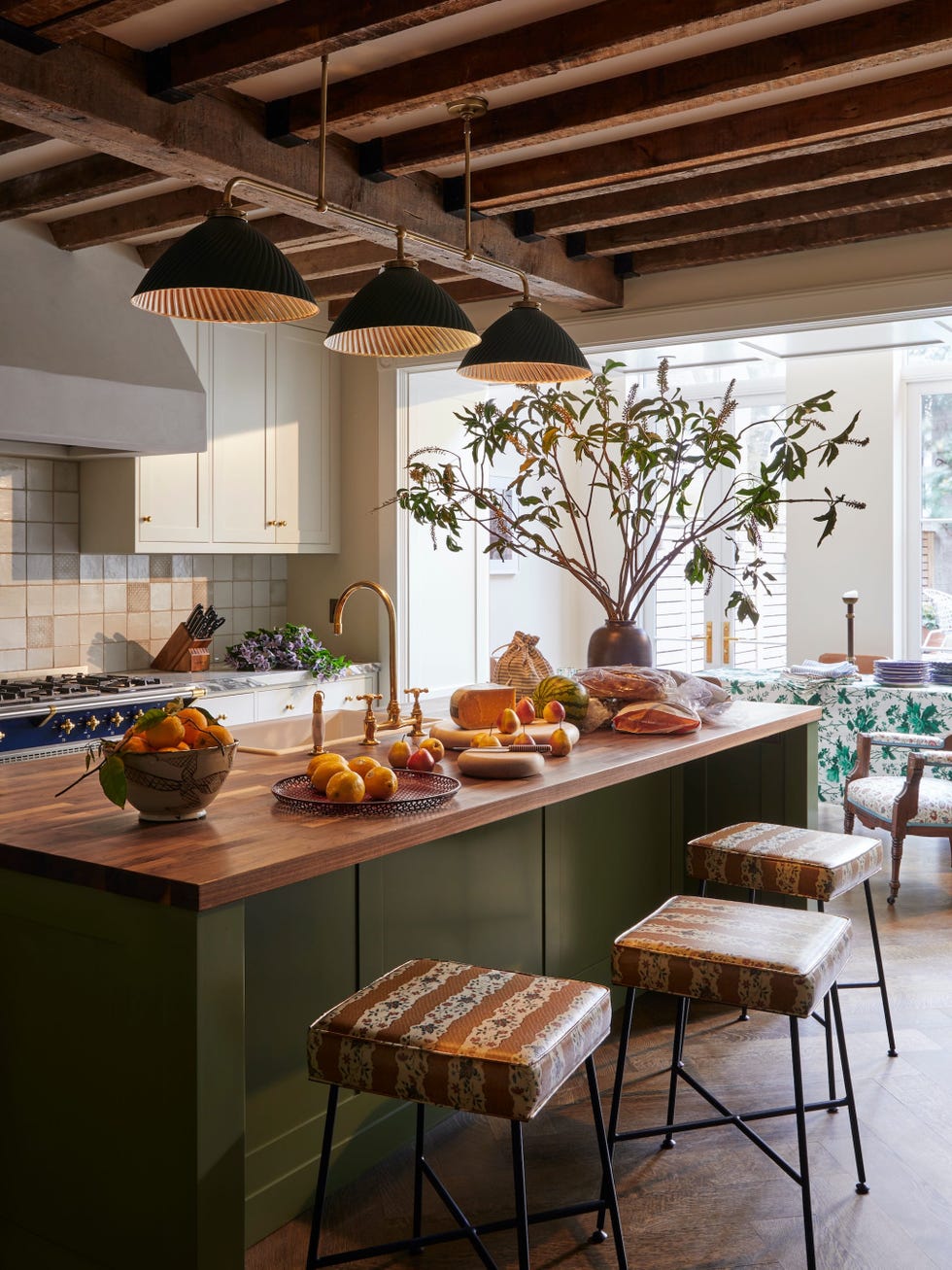 Modern kitchen with fruit display and seating area.