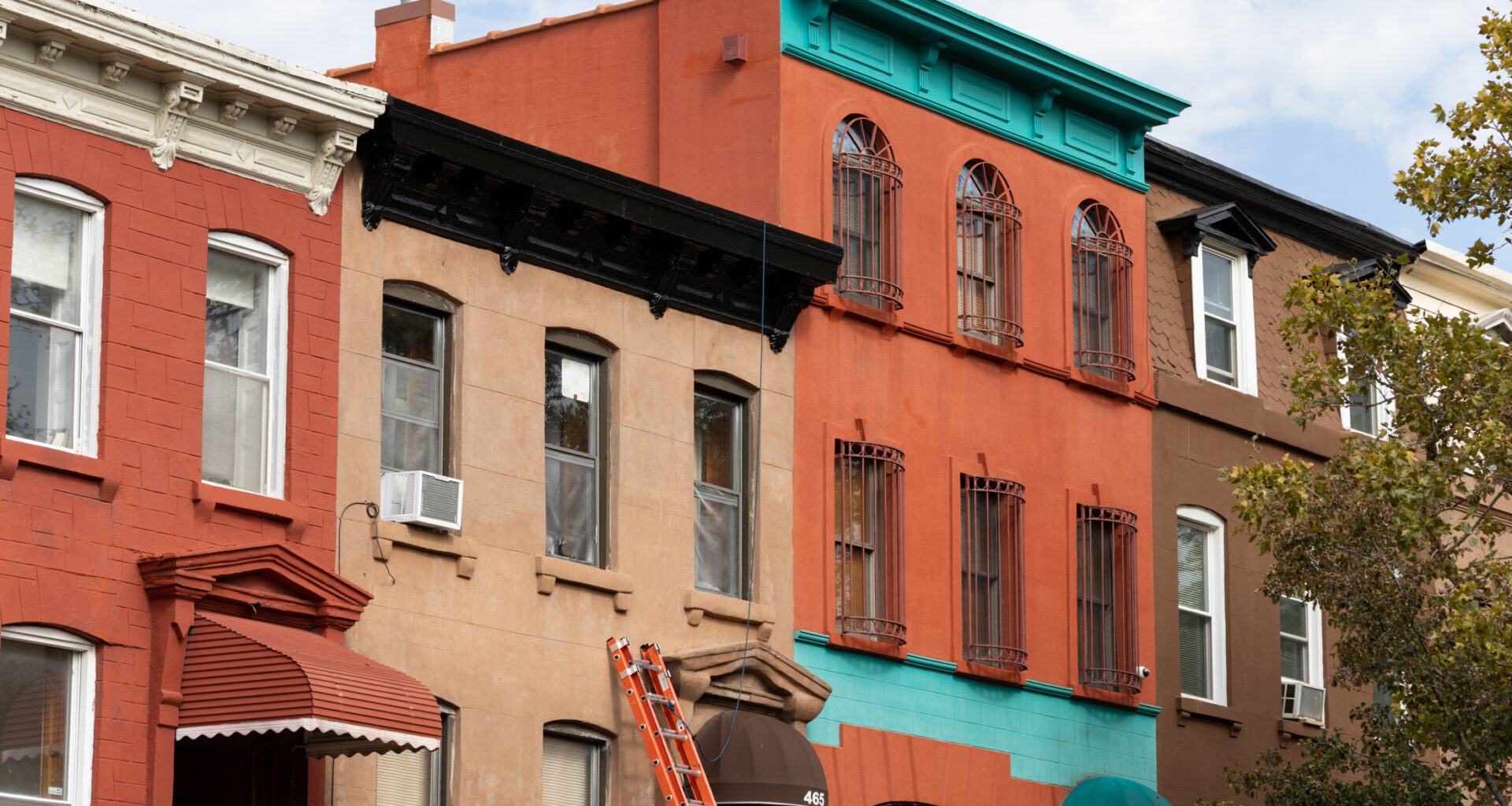 ladder leaning against a brownstone