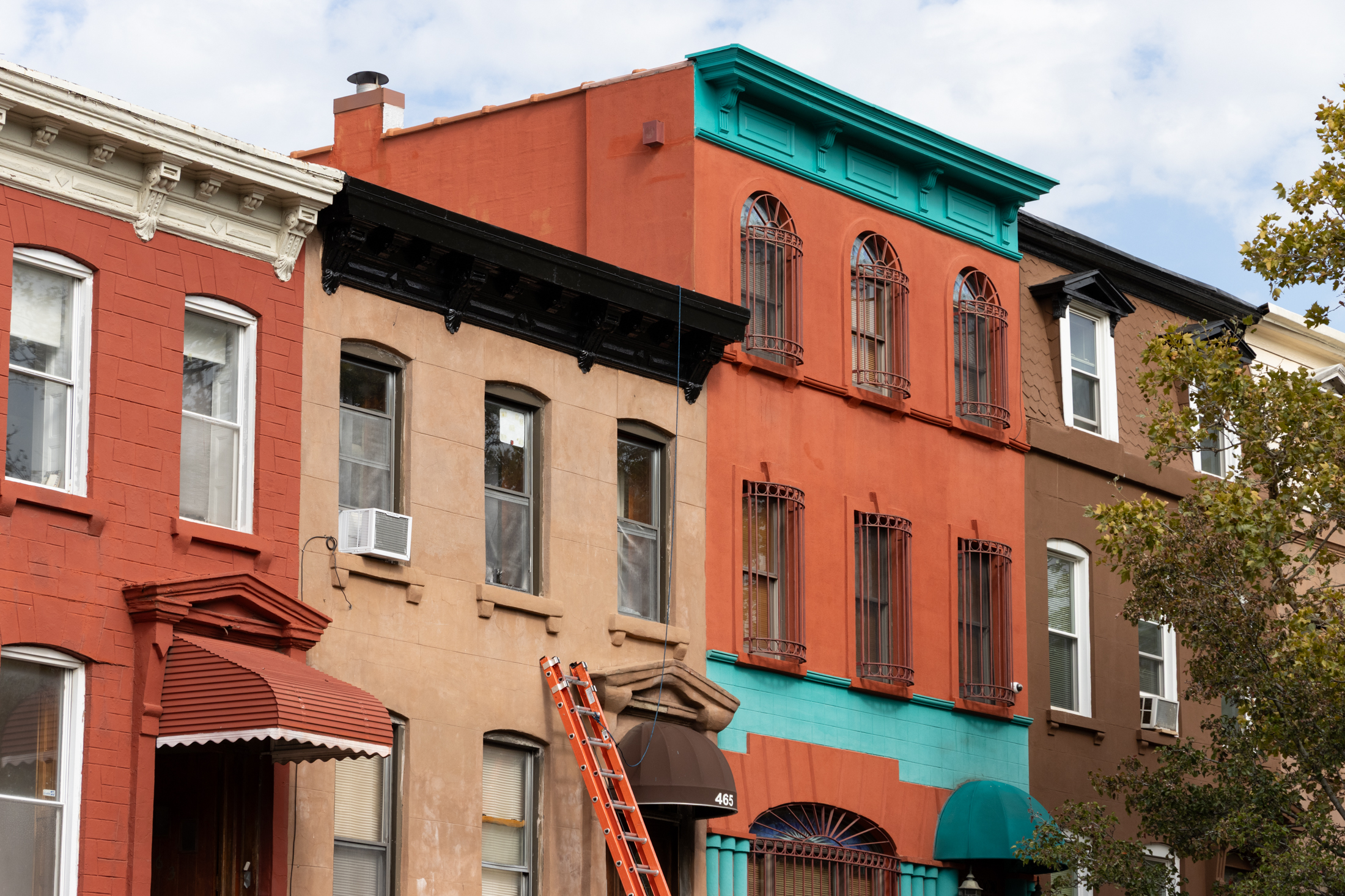 ladder leaning against a brownstone
