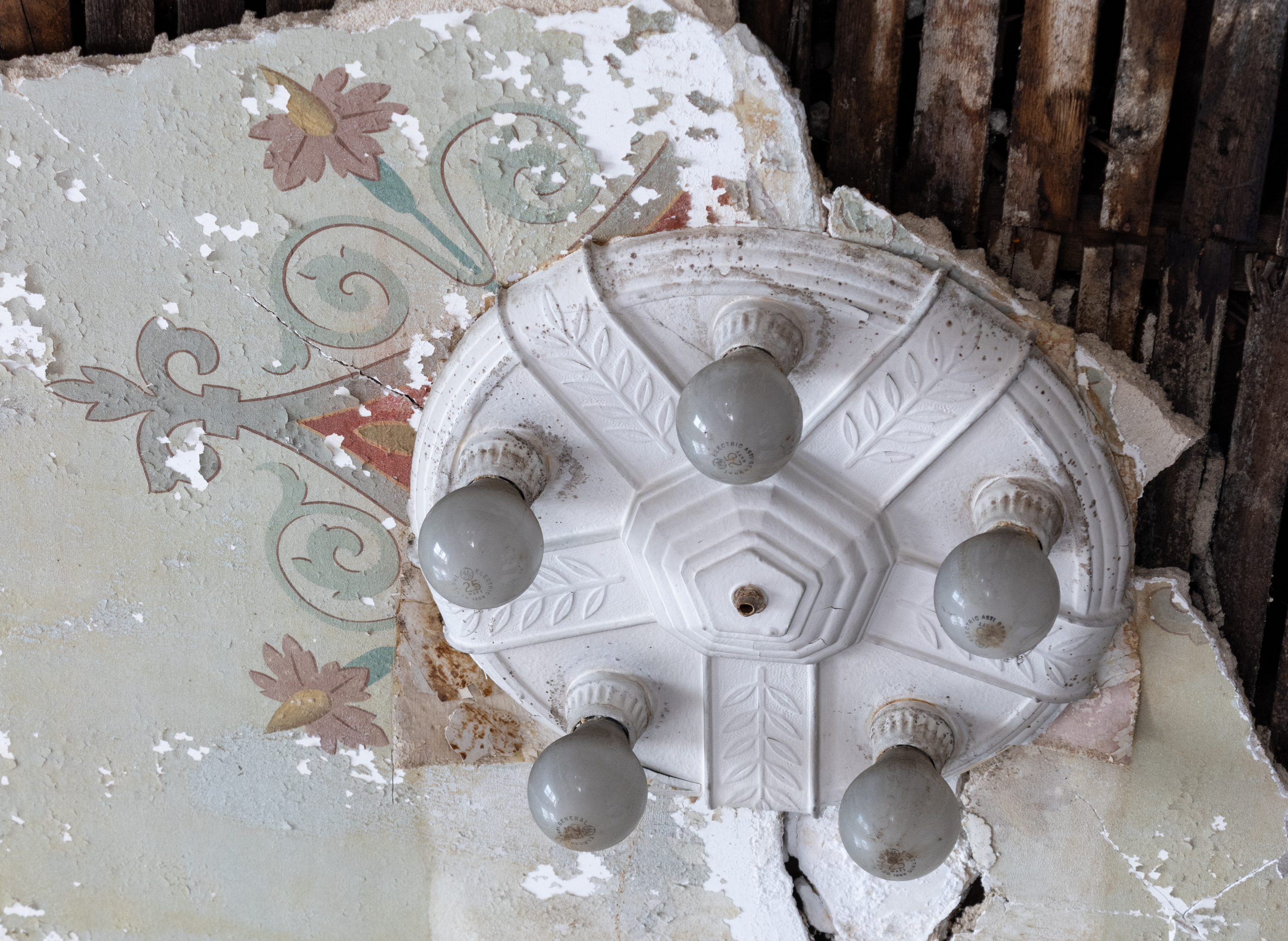an art deco ceiling fixture over a stenciled ceiling design