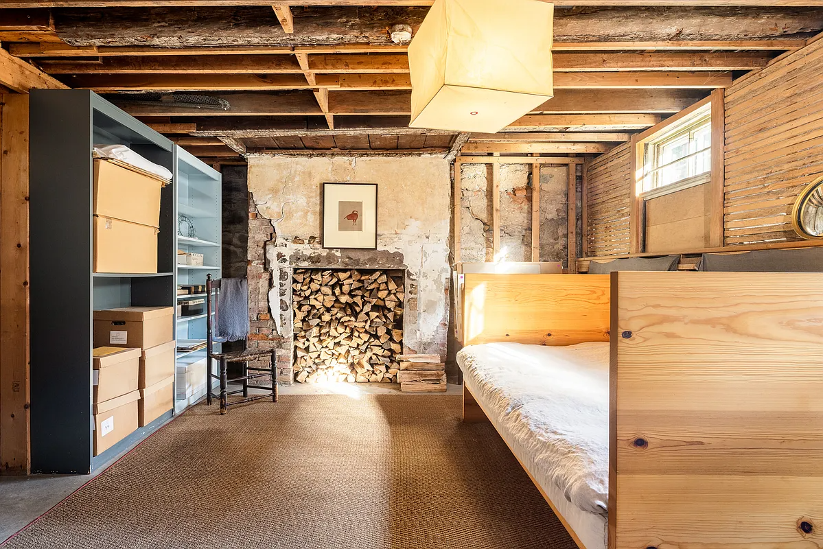 garden level room with exposed rafters, brick. lathe, and a wood day bed
