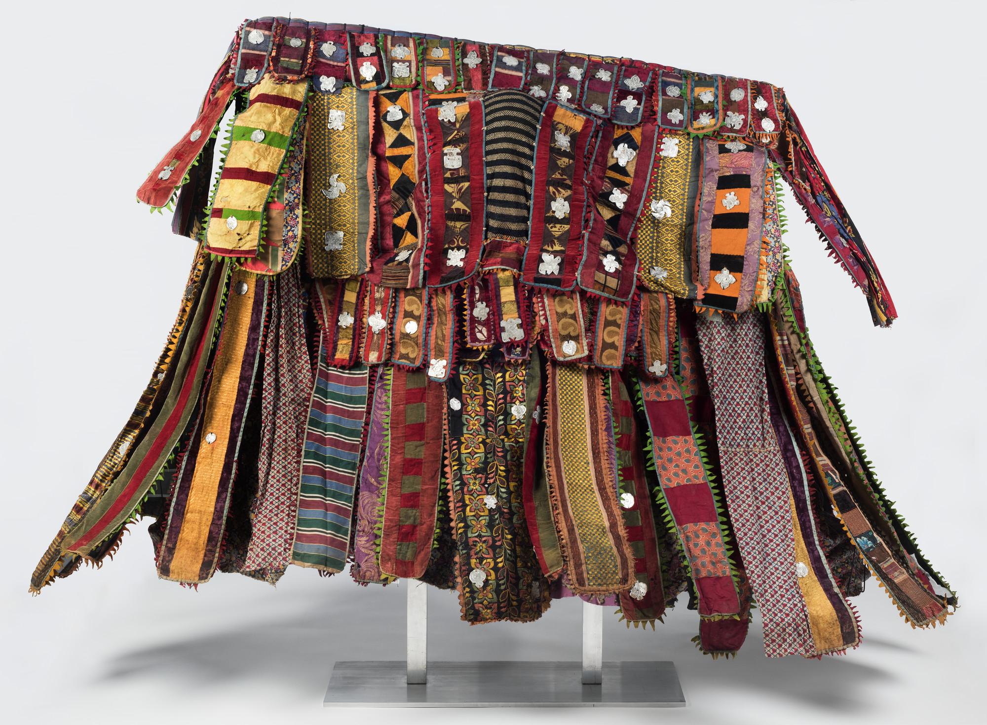 Yorùbá artist, “Paka Egúngún“ (Masquerade Dance Costume). Lekewọgbẹ compound, Ògbómọ̀ṣọ́, Ọ̀yọ́ State, Nigeria, ca. 1920–48. Cotton, wool, wood, silk, synthetic textiles, indigo, and aluminum