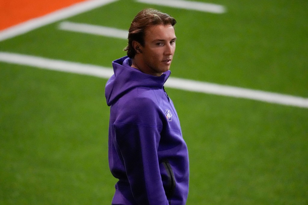 Cade Klubnik, wearing a purple hoodie, on a football field during NFL Pro Day.