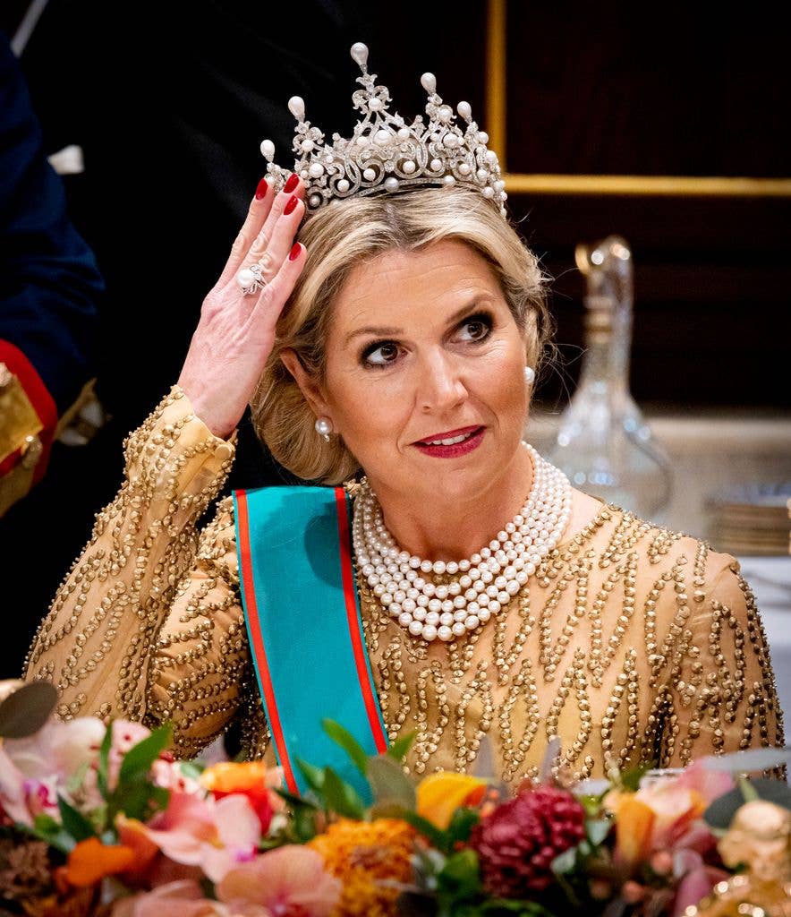Queen Maxima holding tiara on her head