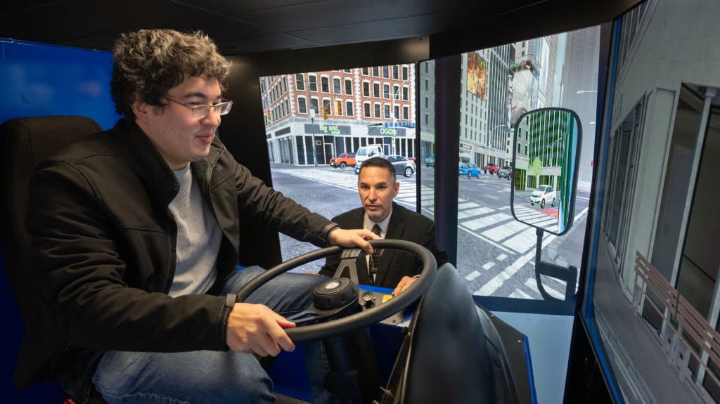 Cost drives the virtual bus while the MTA’s Alvaro Brandon looks on. J.C. Rice for NY Post