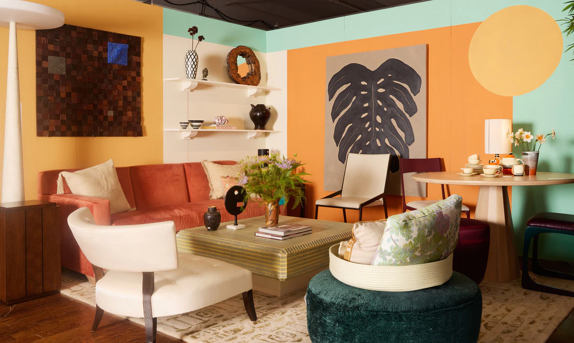 Colorful eclectic living room with vibrant walls, abstract art, varied seating, and decorative accents on shelves.
