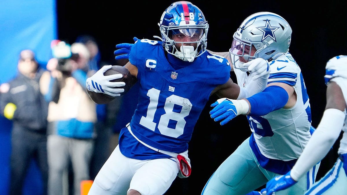 New York Giants wide receiver Darius Slayton running with the ball on a football field