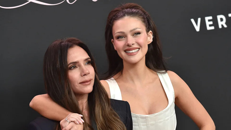 Victoria Beckham and Nicola Peltz pose together, smiling at an event.
